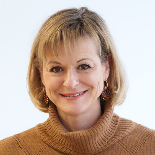 Portrait einer Frau mit schulterlangen blonden Haaren und freundlichem Lächeln.